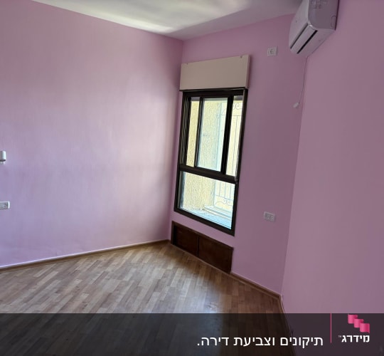 קירות ורודים בחדר עם רצפת עץ